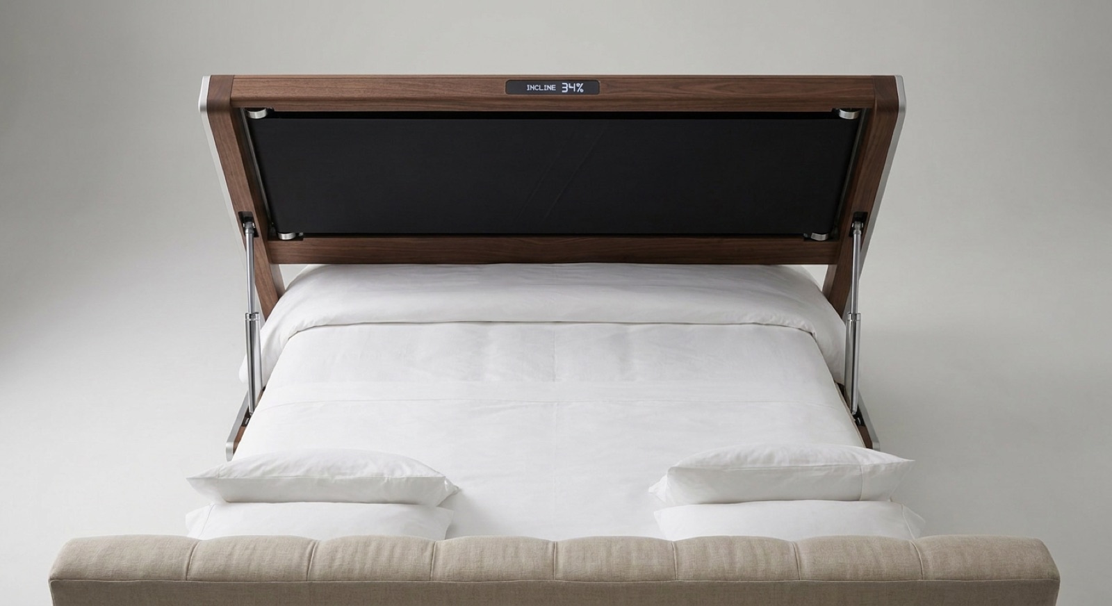WalkingBed Incline with the treadmill footboard tilted over the bed on hydraulic pistons, display reading Incline 34%